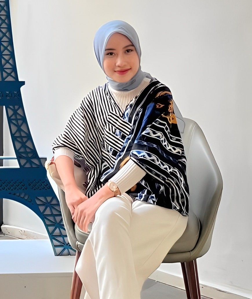 Inneke Twita smiling in a blue amazing dress and blue scraf hijab